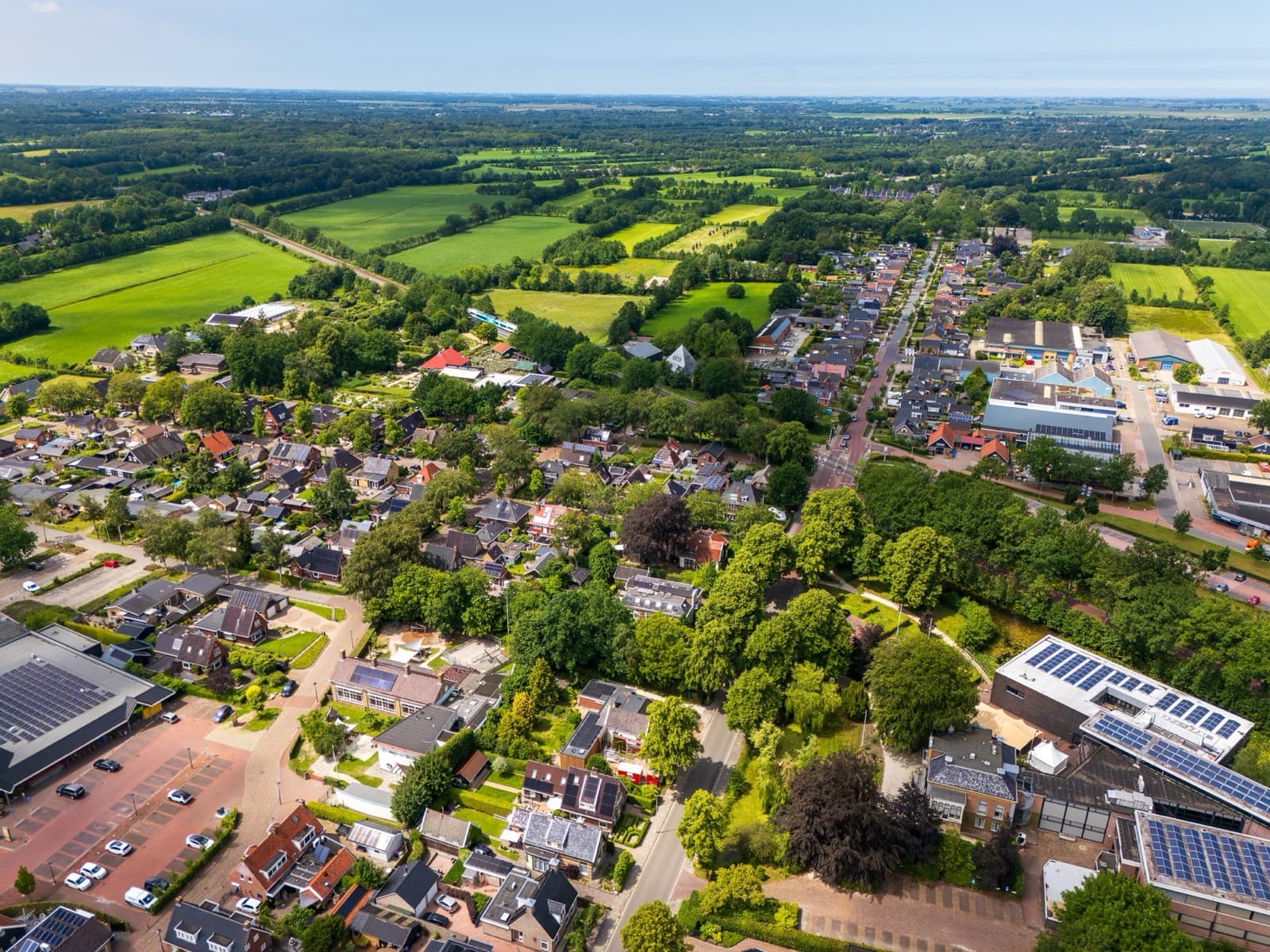 Dorp met weilanden en bos tot aan de horizon