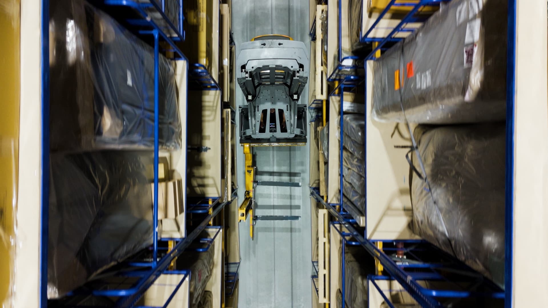 Heftruck van bovenaf tussen de stellingen