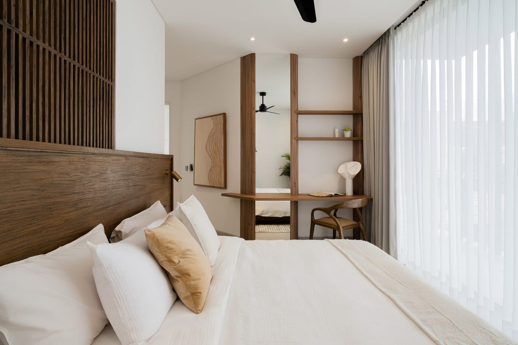 Slaapkamer met werkplek en houten wandkast