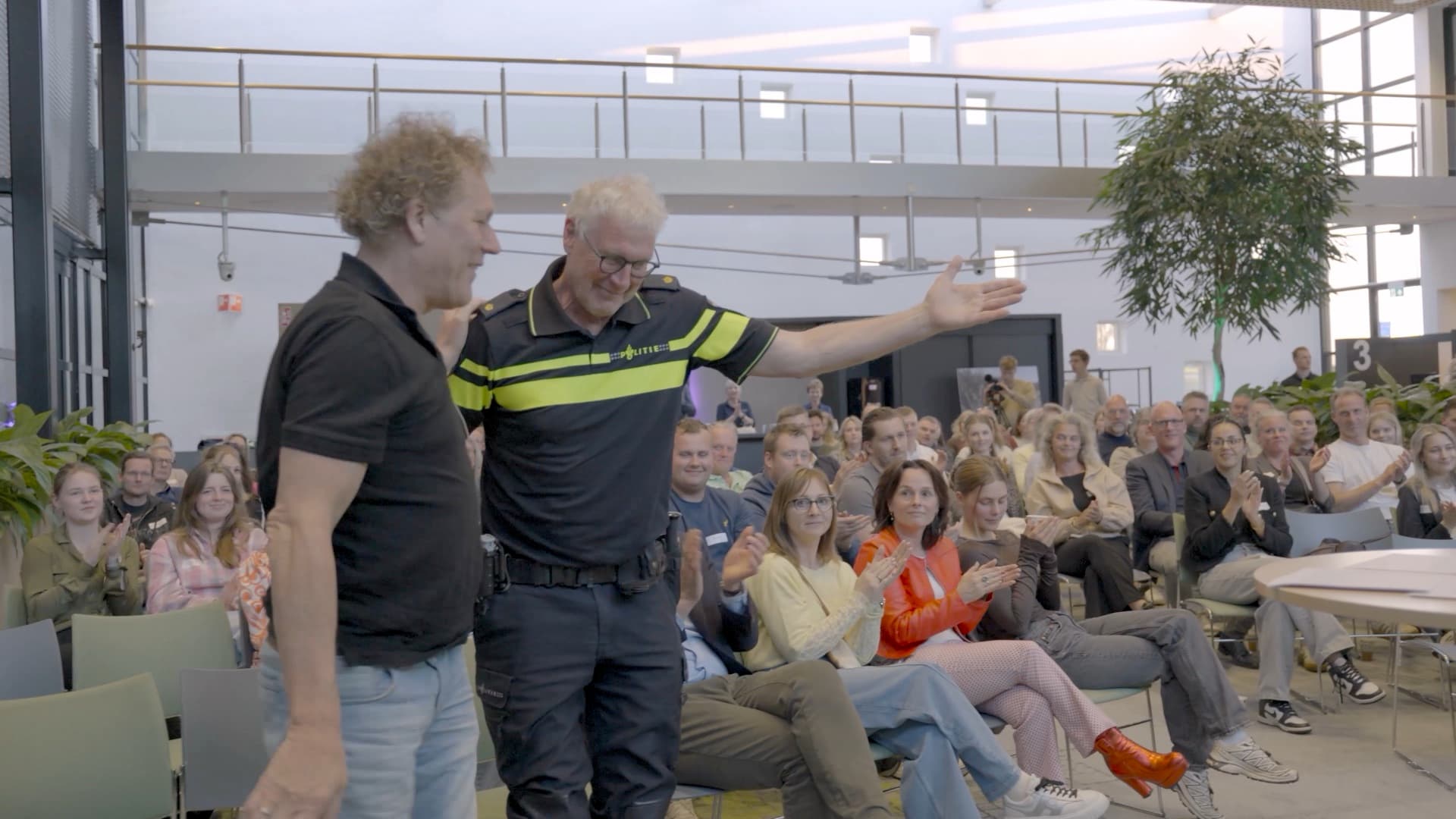 Kees van der Spek en een politieagent in gesprek met het publiek