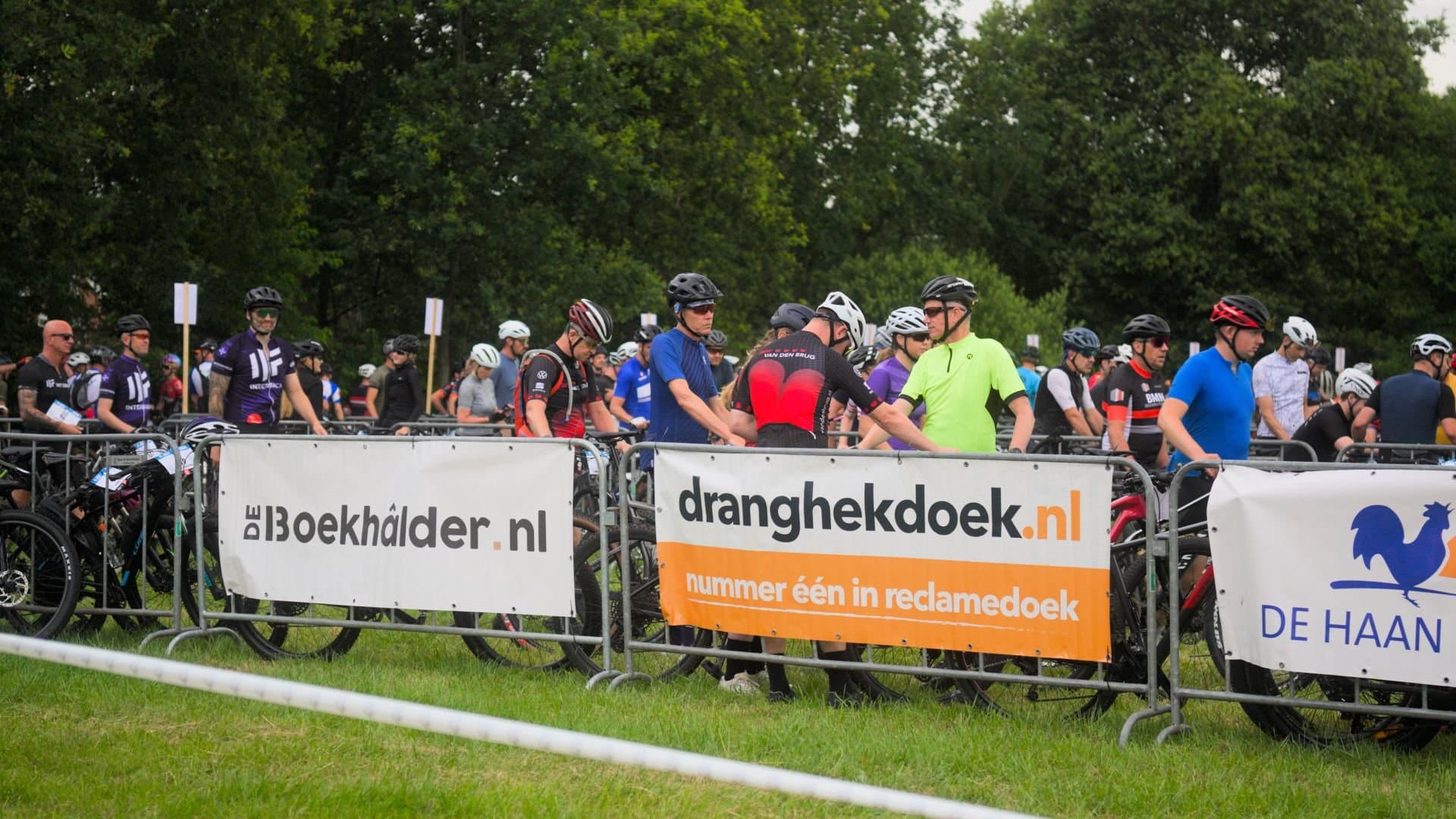 Mountainbikers achter dranghekken met dranghekdoeken van Dranghekdoek.nl