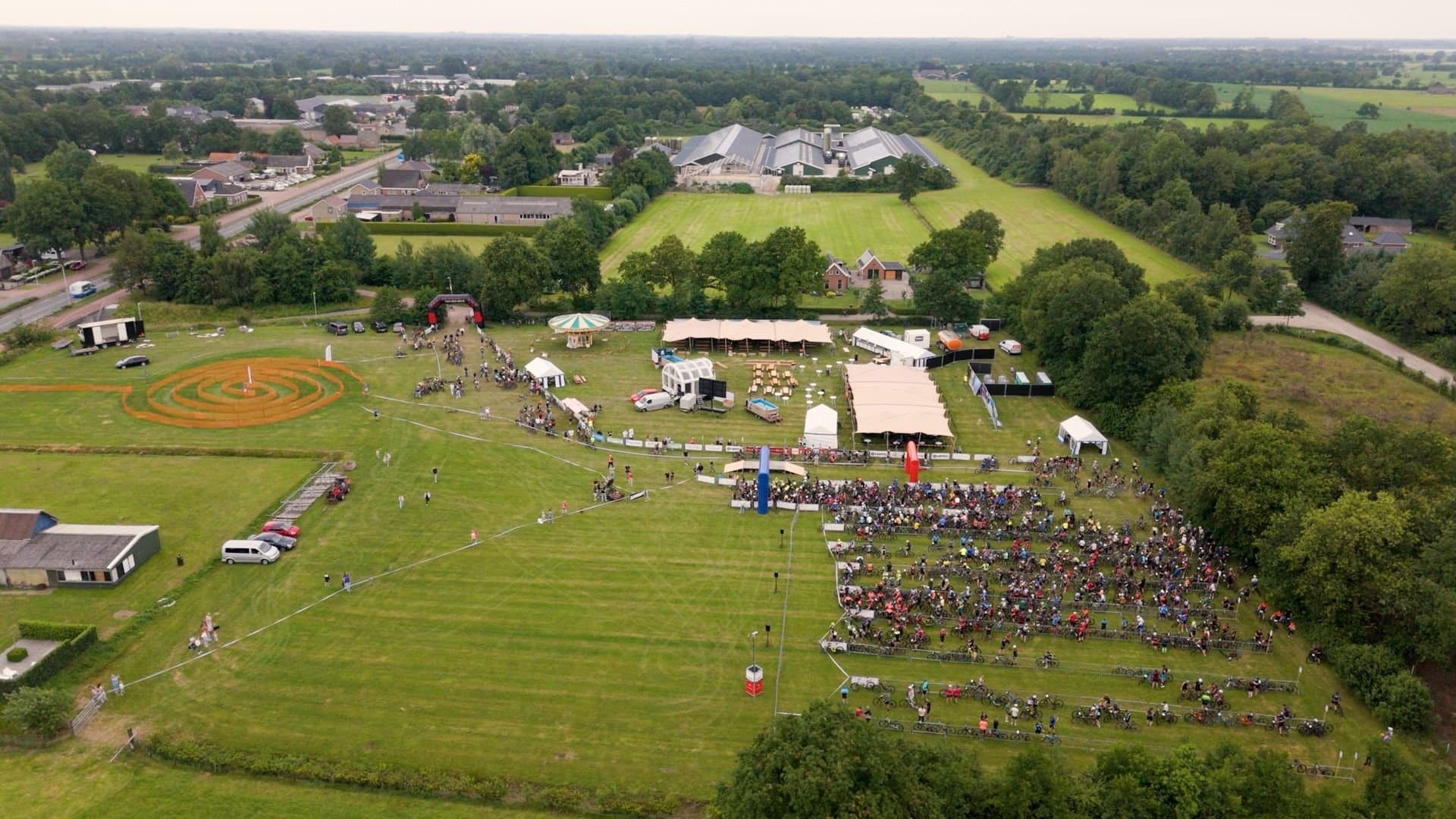 Luchtbeeld van het evenemententerrein met honderden deelnemers bij de start