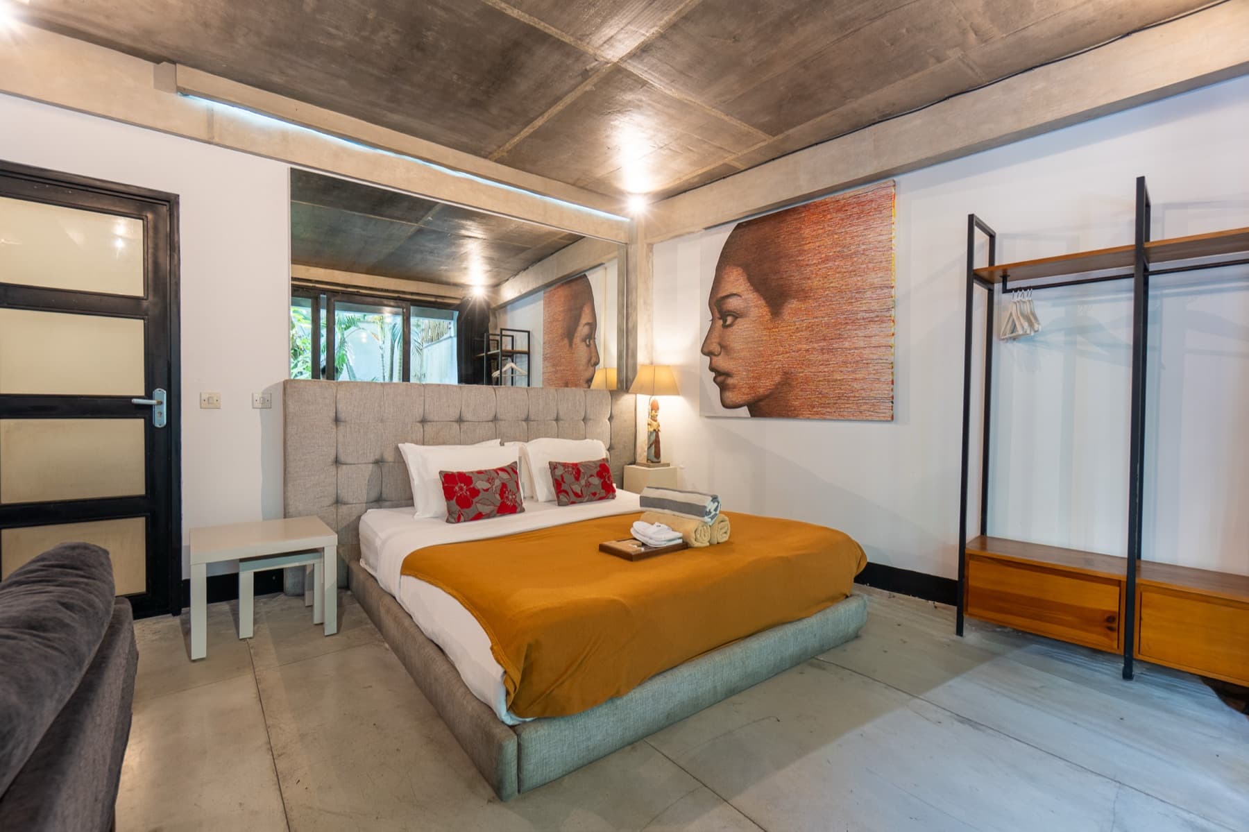 Slaapkamer met kledingrek en schilderij