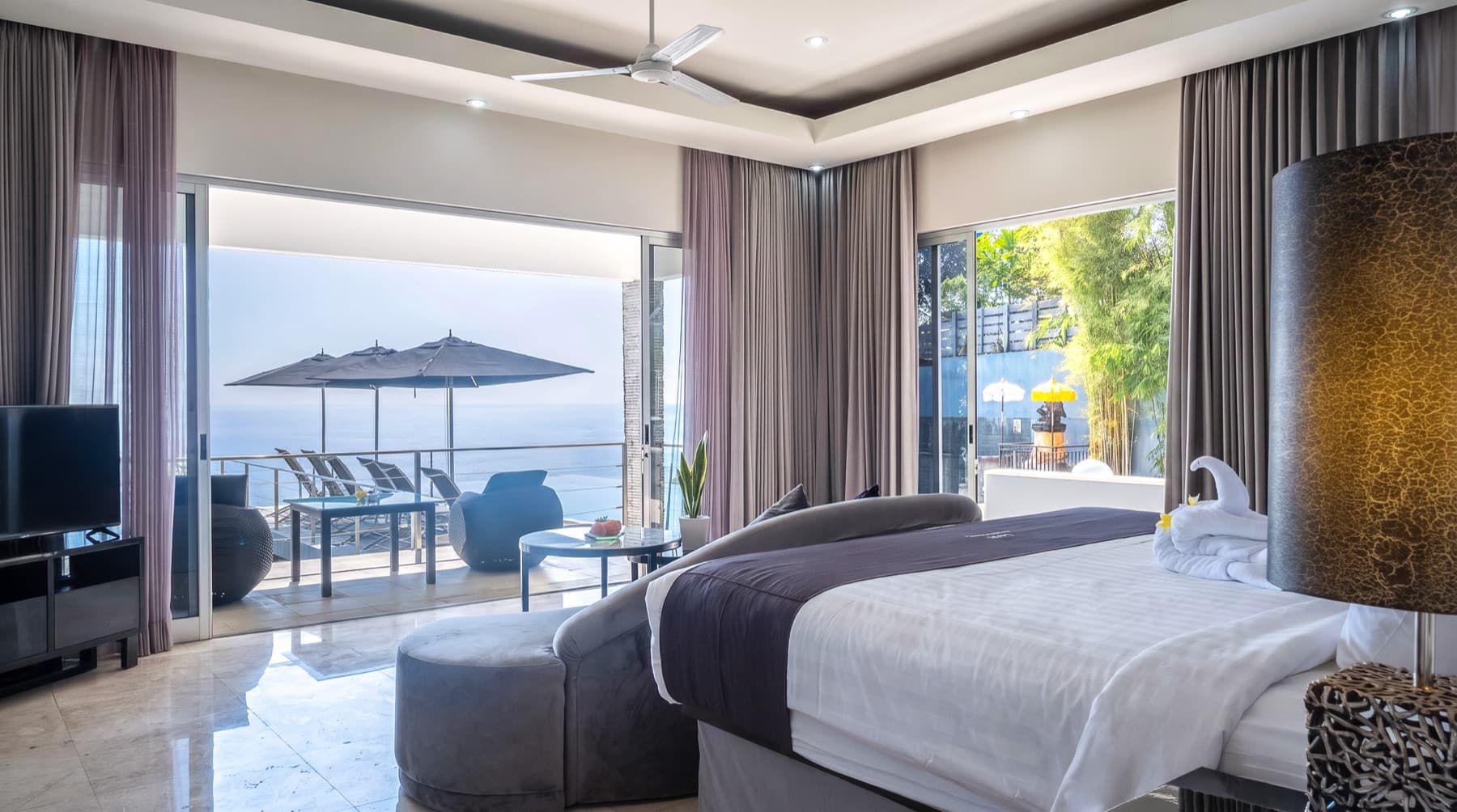 Slaapkamer met terras en parasols boven de oceaan