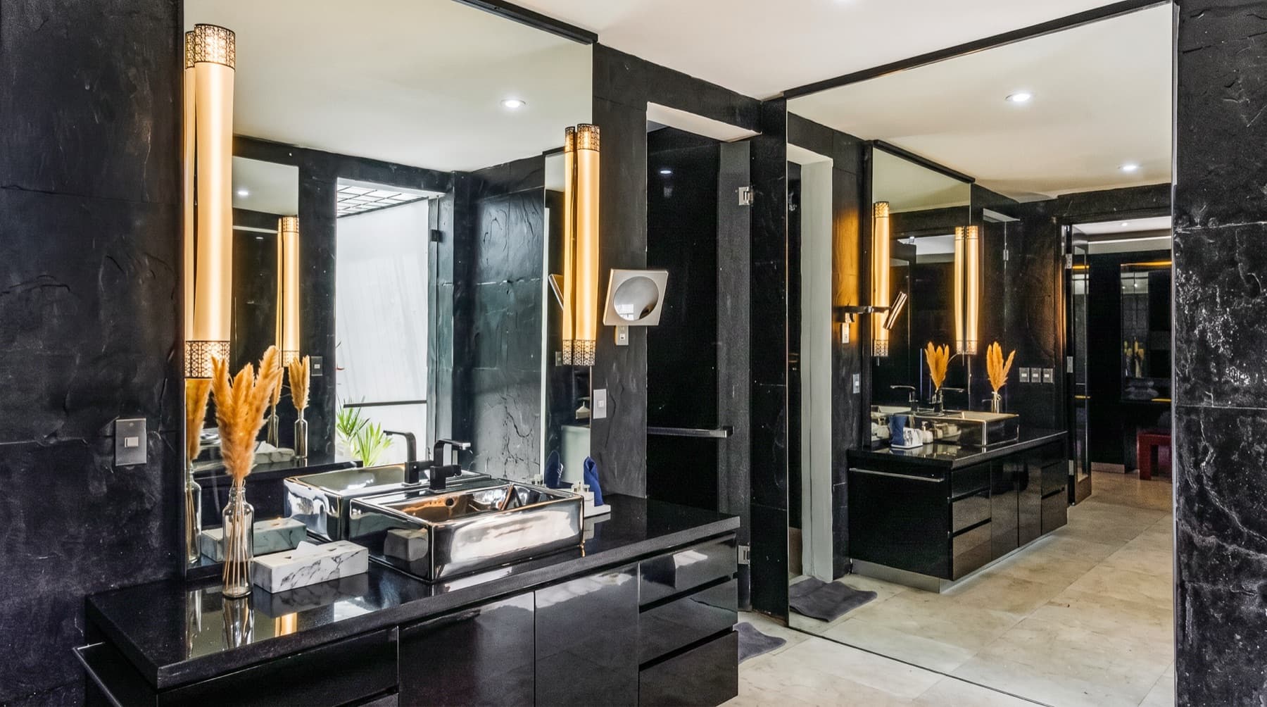 Badkamer met zwart marmer, spiegels en wastafels