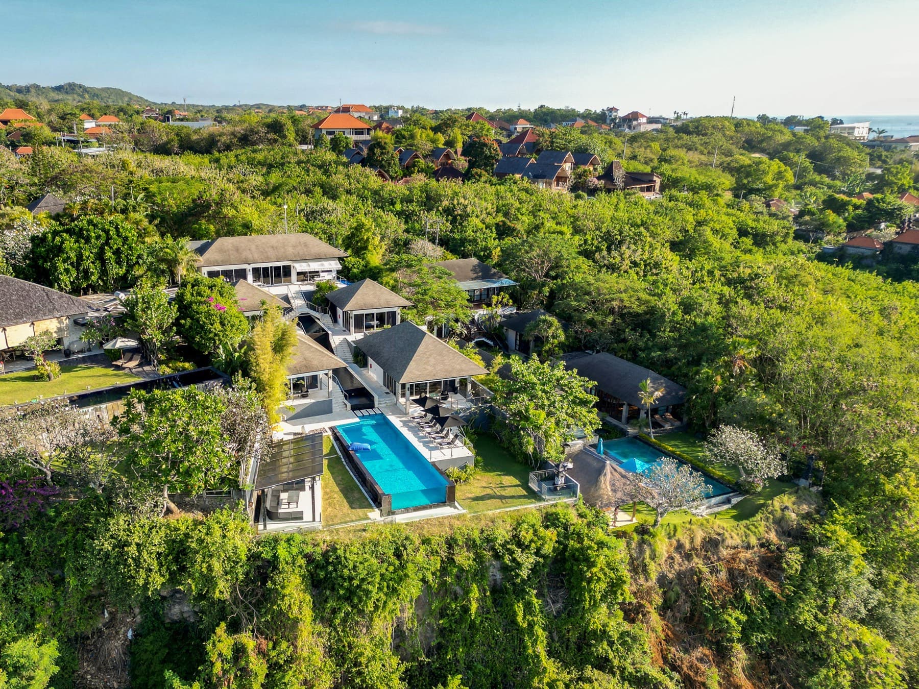 Dronebeeld van de villa’s met zwembaden tussen het groen