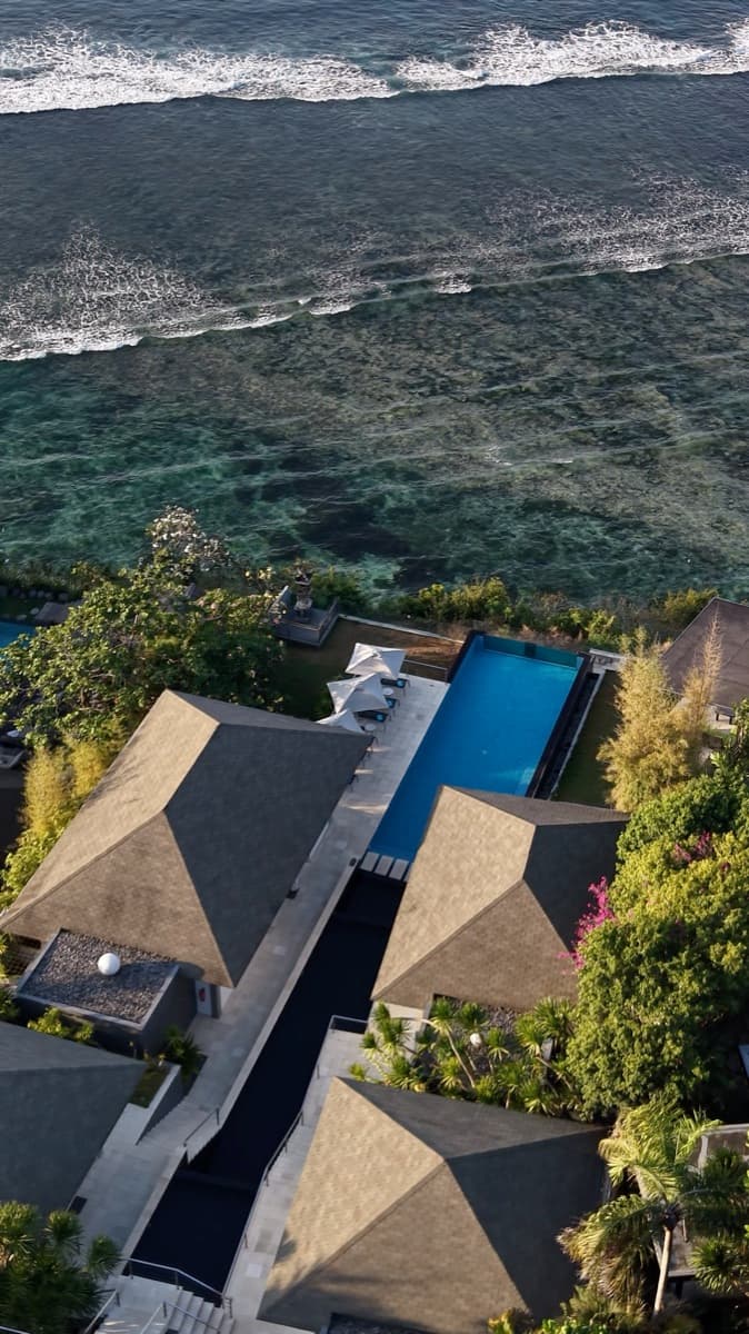 Dronebeeld van villa’s met zwembaden op de klif boven zee