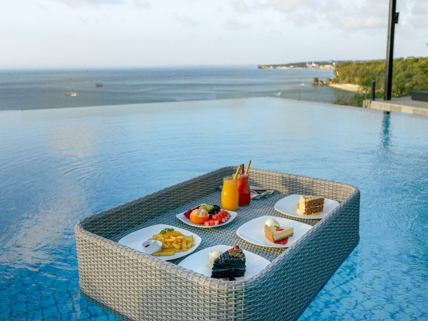 Drijvend dienblad met eten en drankjes in de infinity pool
