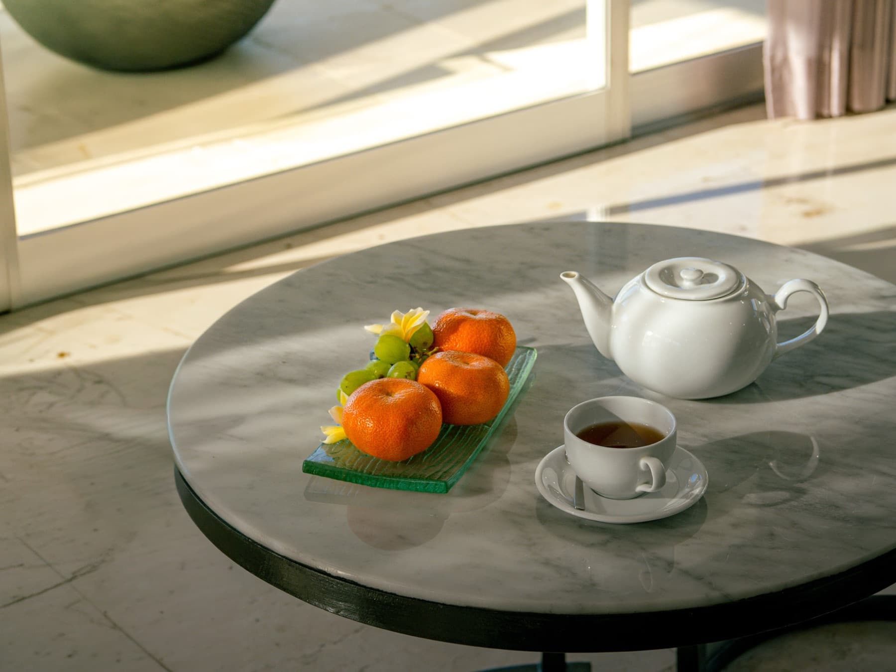 Thee en mandarijnen op een marmeren tafel in het zonlicht